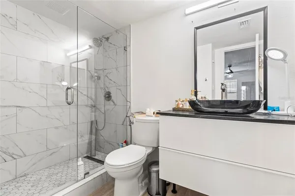 a bathroom with a sink a toilet and shower