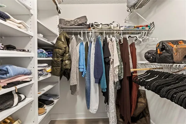 a view of walk in closet with clothes and shoes