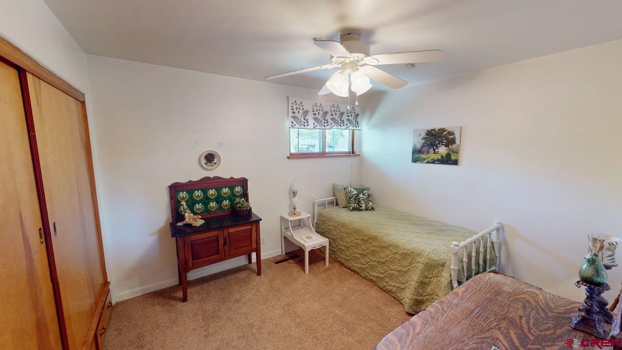 96 El Rio Drive Alamosa, CO 81101 - Photo 10 of 18 a bedroom with a bed and a chandelier