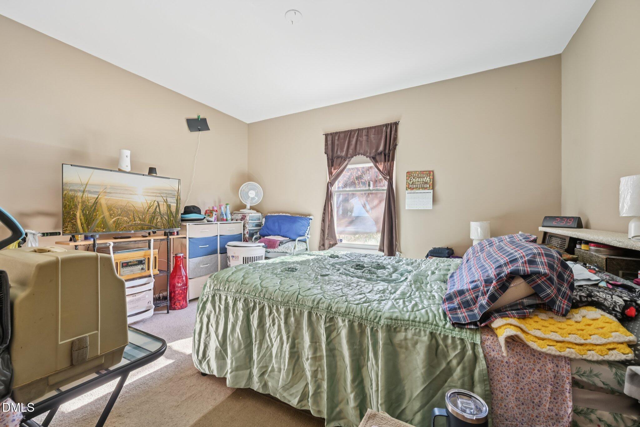 2706 Ramblegate Lane Durham, NC 27705 - Photo 11 of 28 a bedroom with a bed and a tv