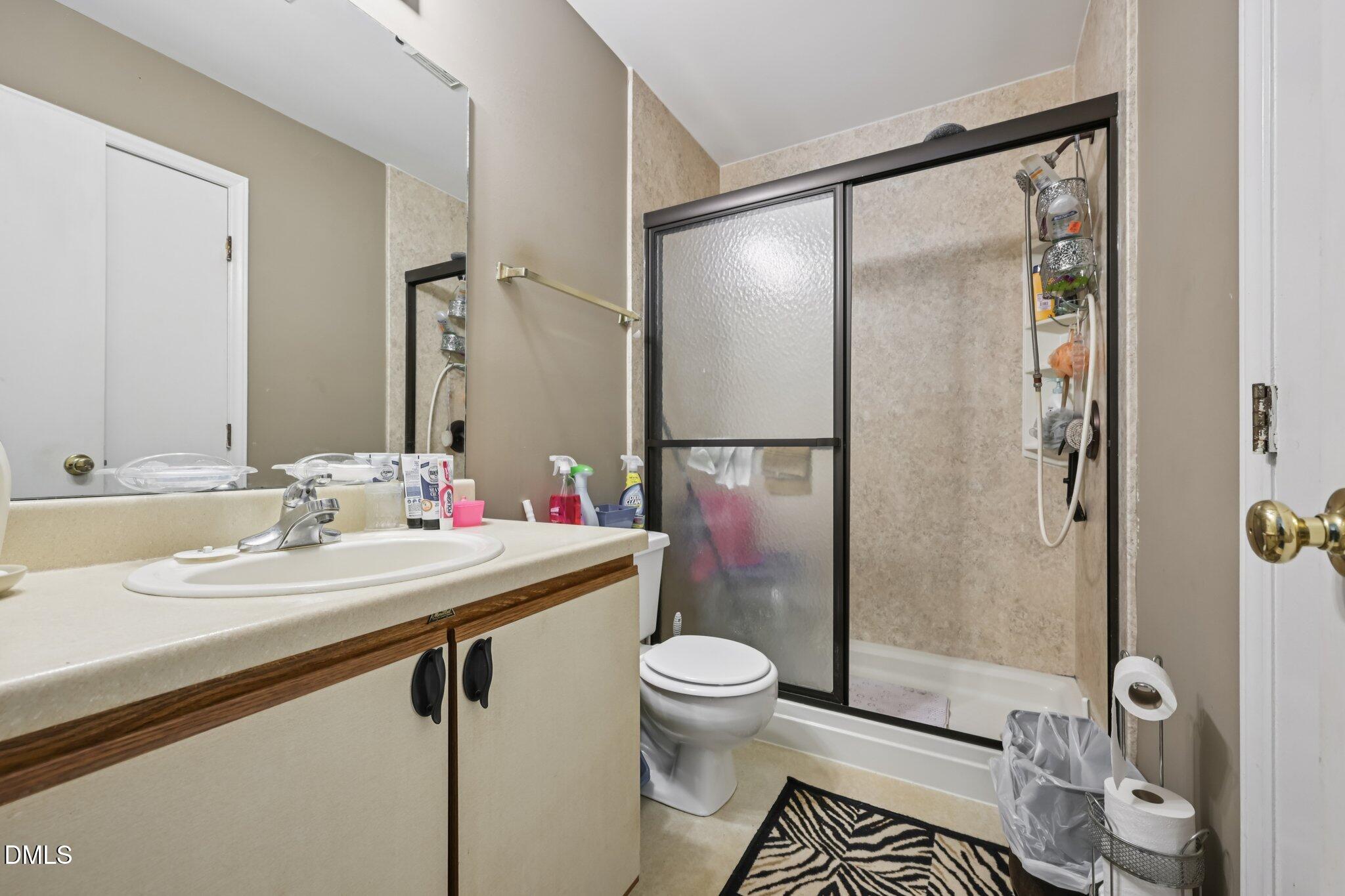 2706 Ramblegate Lane Durham, NC 27705 - Photo 13 of 28 a bathroom with a sink mirror vanity and toilet