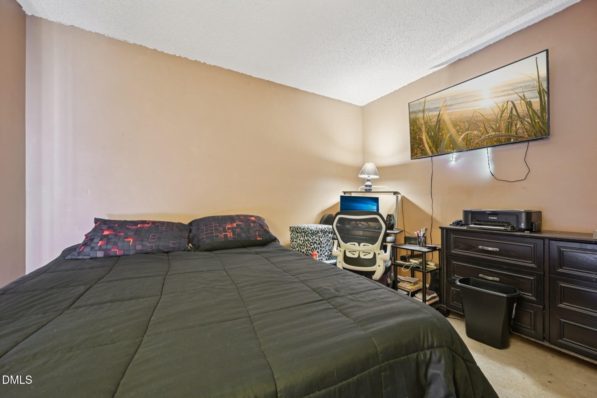 2706 Ramblegate Lane Durham, NC 27705 - Photo 15 of 28 a bedroom with a bed and dresser