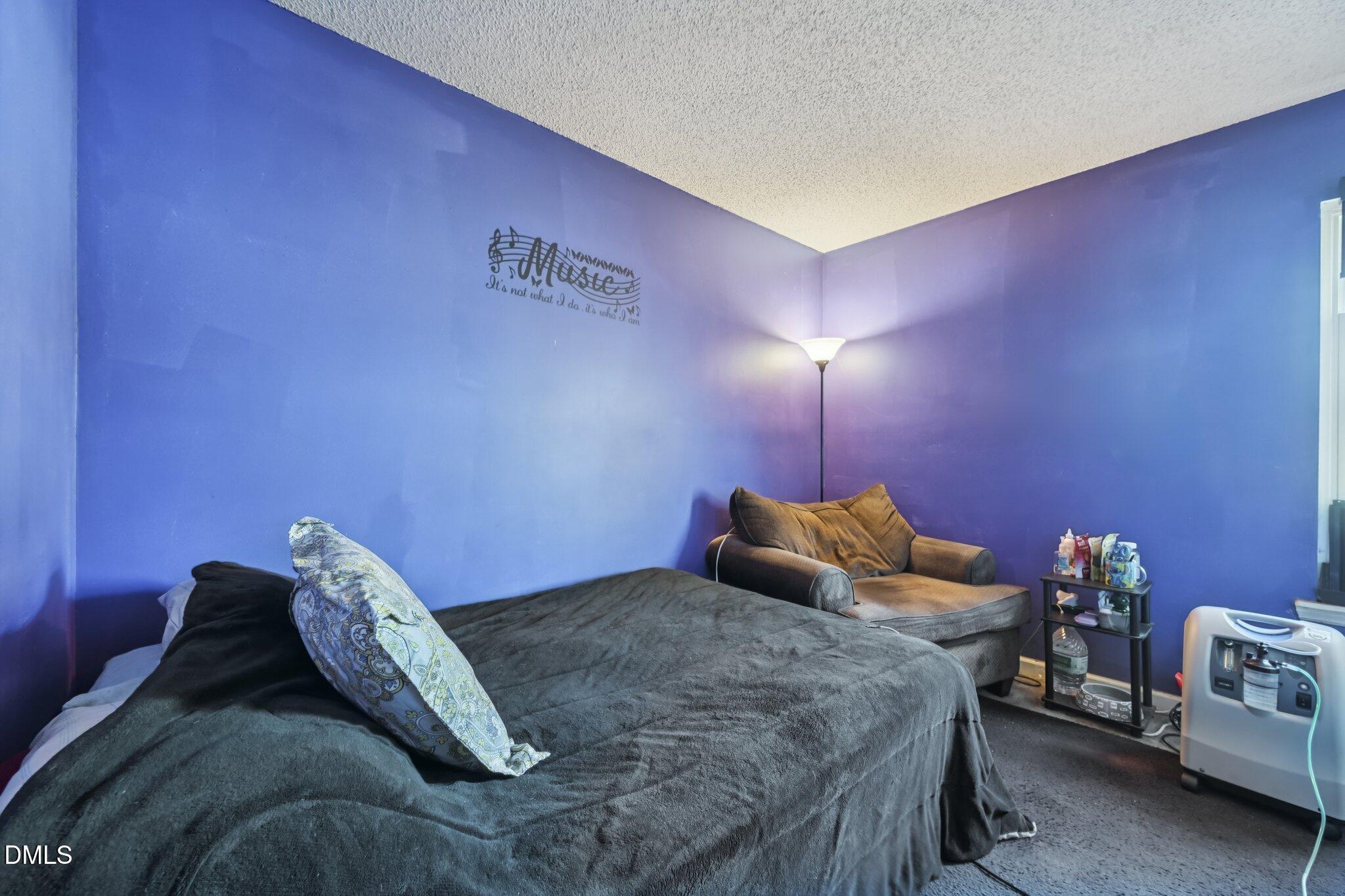 2706 Ramblegate Lane Durham, NC 27705 - Photo 19 of 28 a bedroom with a bed and a lamp with the table
