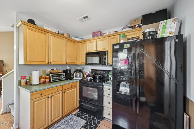 a kitchen with stainless steel appliances granite countertop a refrigerator stove and sink