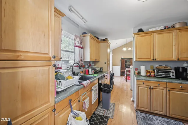 a kitchen with a sink appliances cabinets and a window