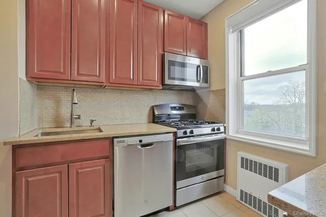 a kitchen with stainless steel appliances granite countertop a stove a sink and a microwave