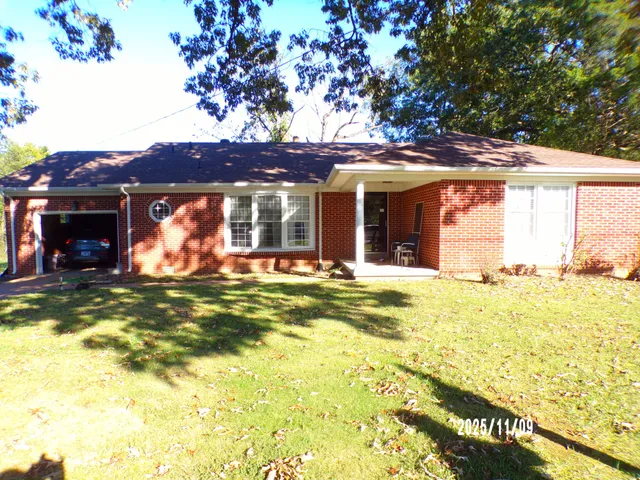 a view of a house with a large tree