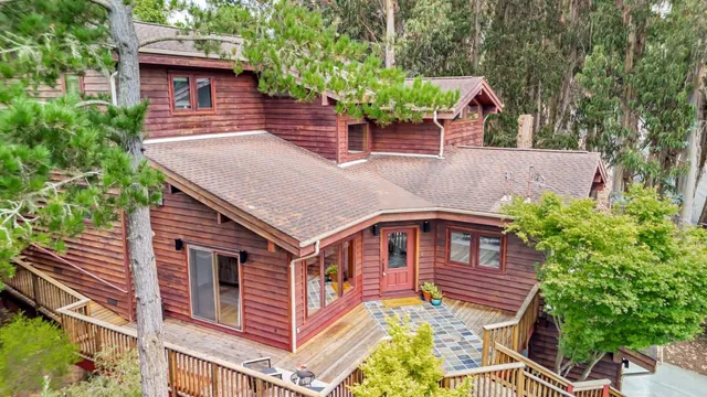 a aerial view of a house with balcony and trees