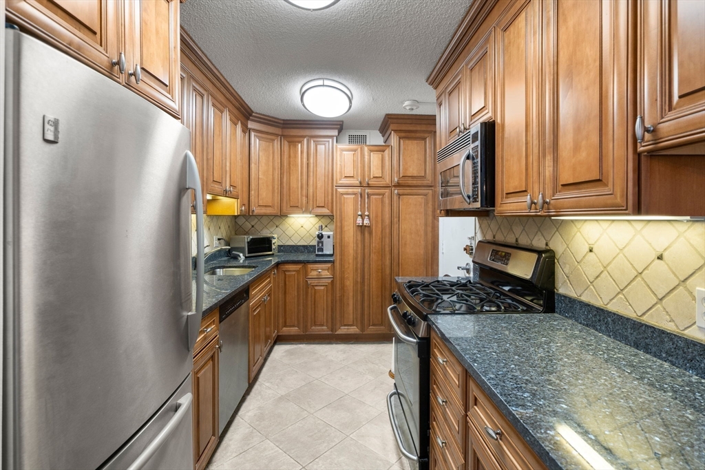 33 Pond Avenue, Unit 405 Brookline, MA 02445 - Photo 2 of 17 a kitchen with stainless steel appliances granite countertop a refrigerator a stove and a sink