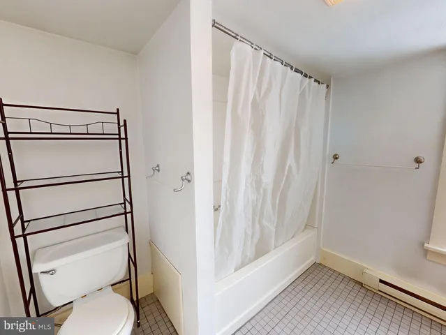 a bathroom with a shower curtain and a toilet