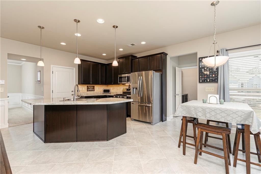 152 Greatwood Lane Villa Rica, GA 30180 - Photo 11 of 48 a kitchen with stainless steel appliances granite countertop a refrigerator a sink a stove a dining table and chairs