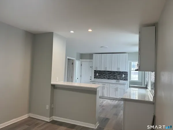 a kitchen with granite countertop white cabinets and stainless steel appliances