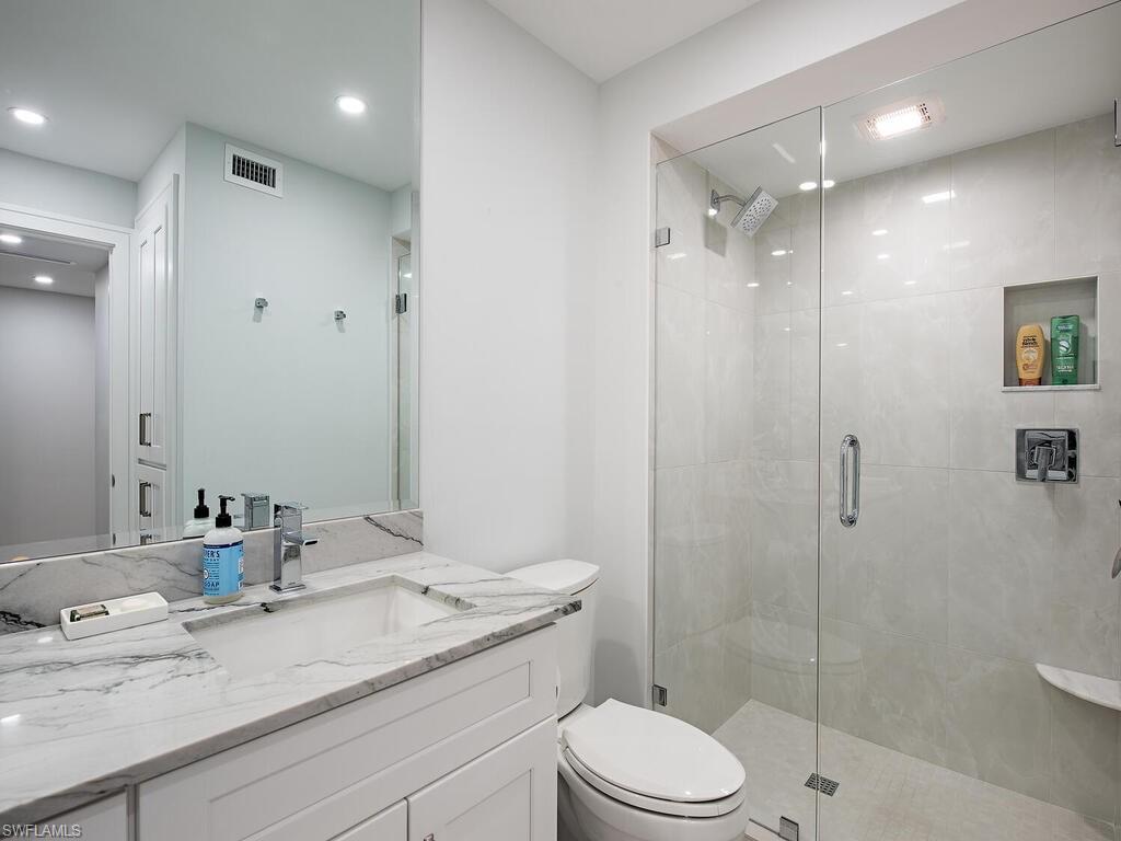 100 Wilderness Way, Unit B348 Naples, FL 34105 - Photo 10 of 15 Bathroom featuring walk in shower, vanity, and toilet