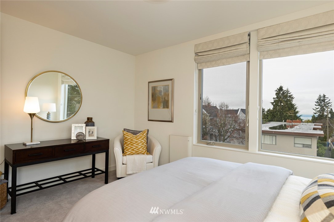 6012 A California Avenue Southwest Seattle, WA 98136 - Photo 16 of 30 a bedroom with a bed a mirror on desk and a large window