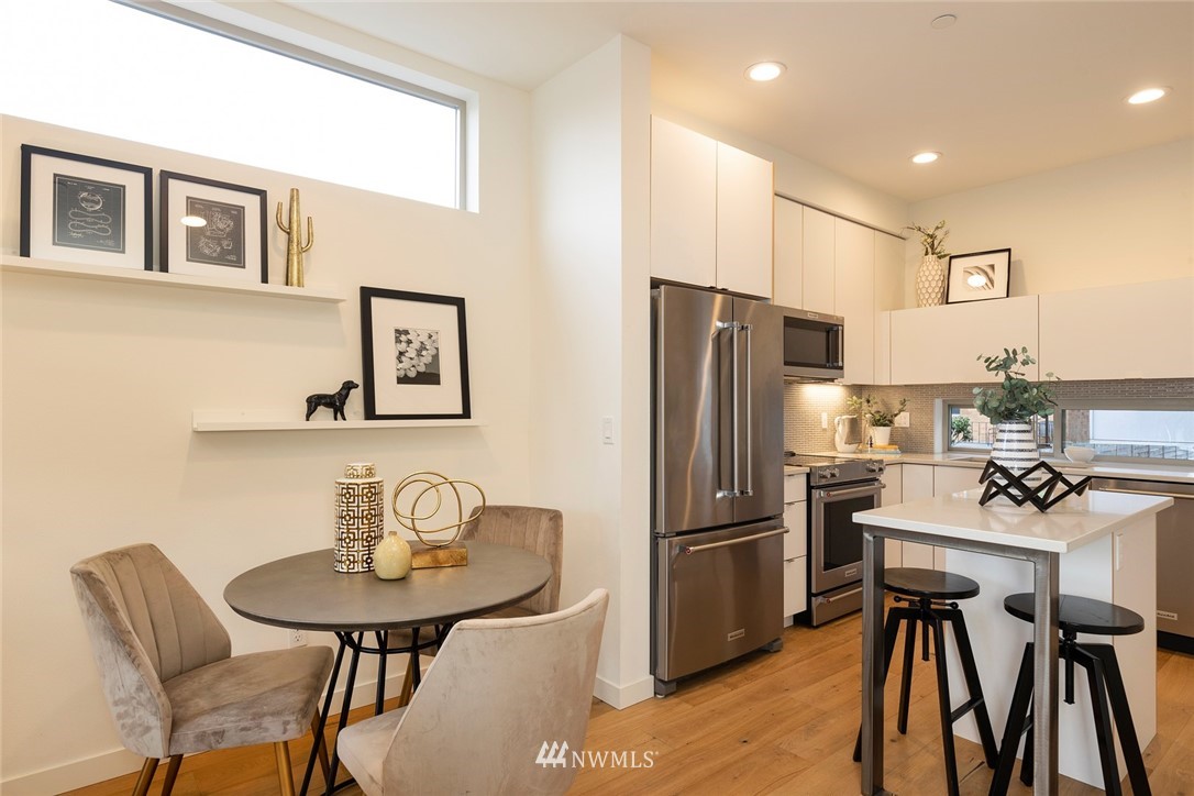 6012 A California Avenue Southwest Seattle, WA 98136 - Photo 9 of 30 a kitchen with stainless steel appliances a table chairs and refrigerator