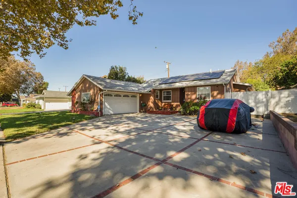 a front view of a house with cars parked