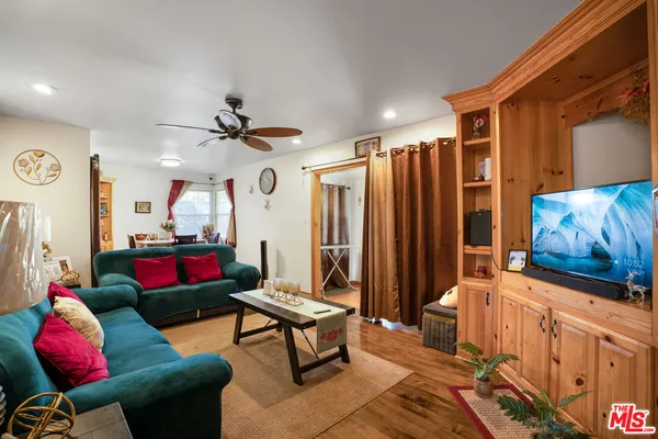 a living room with furniture a ceiling fan and a rug