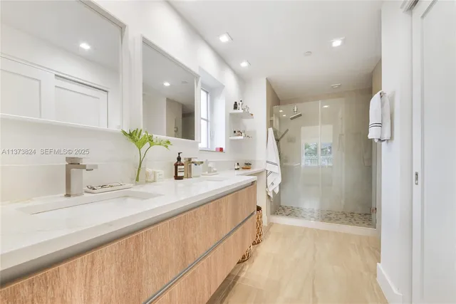 a bathroom with a granite countertop sink mirror and a shower