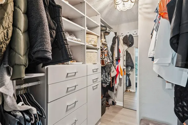 a view of walk in closet with clothes and shoes