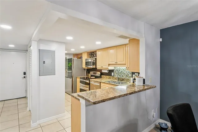 a kitchen with stainless steel appliances granite countertop a sink and a refrigerator