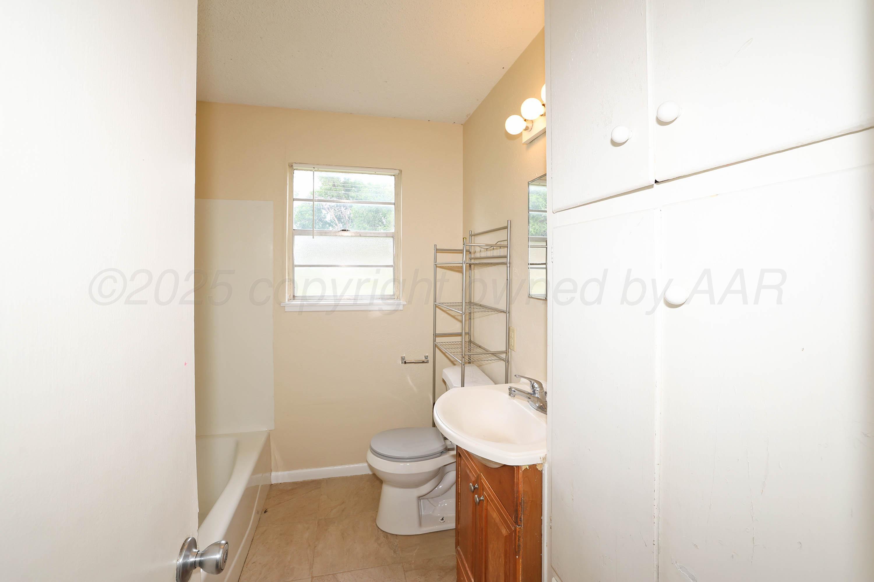 3810 Mesa Verde Drive Amarillo, TX 79107 - Photo 16 of 21 a bathroom with a sink mirror vanity and toilet