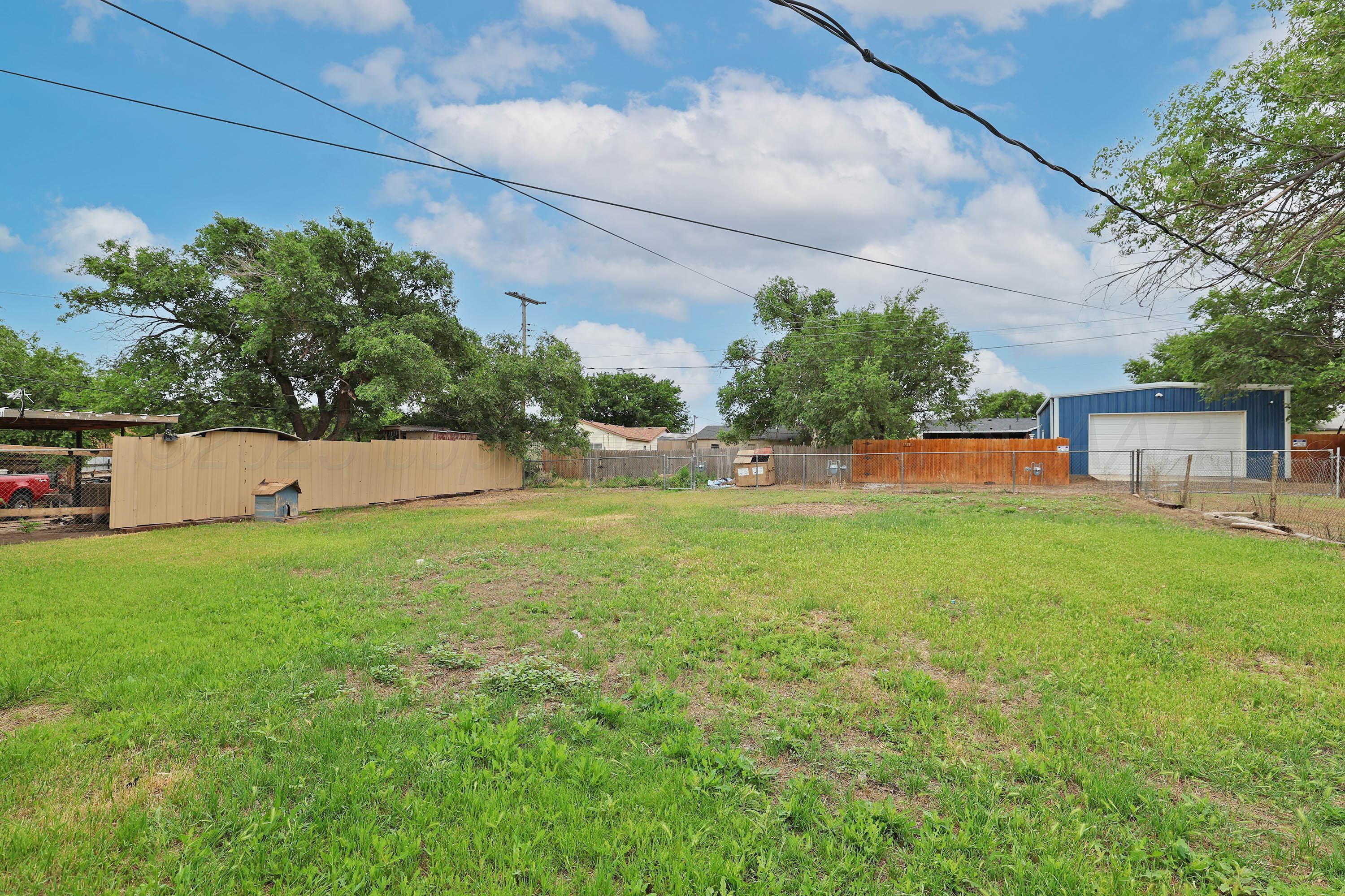 3810 Mesa Verde Drive Amarillo, TX 79107 - Photo 20 of 21 a view of a backyard with plants and a large tree