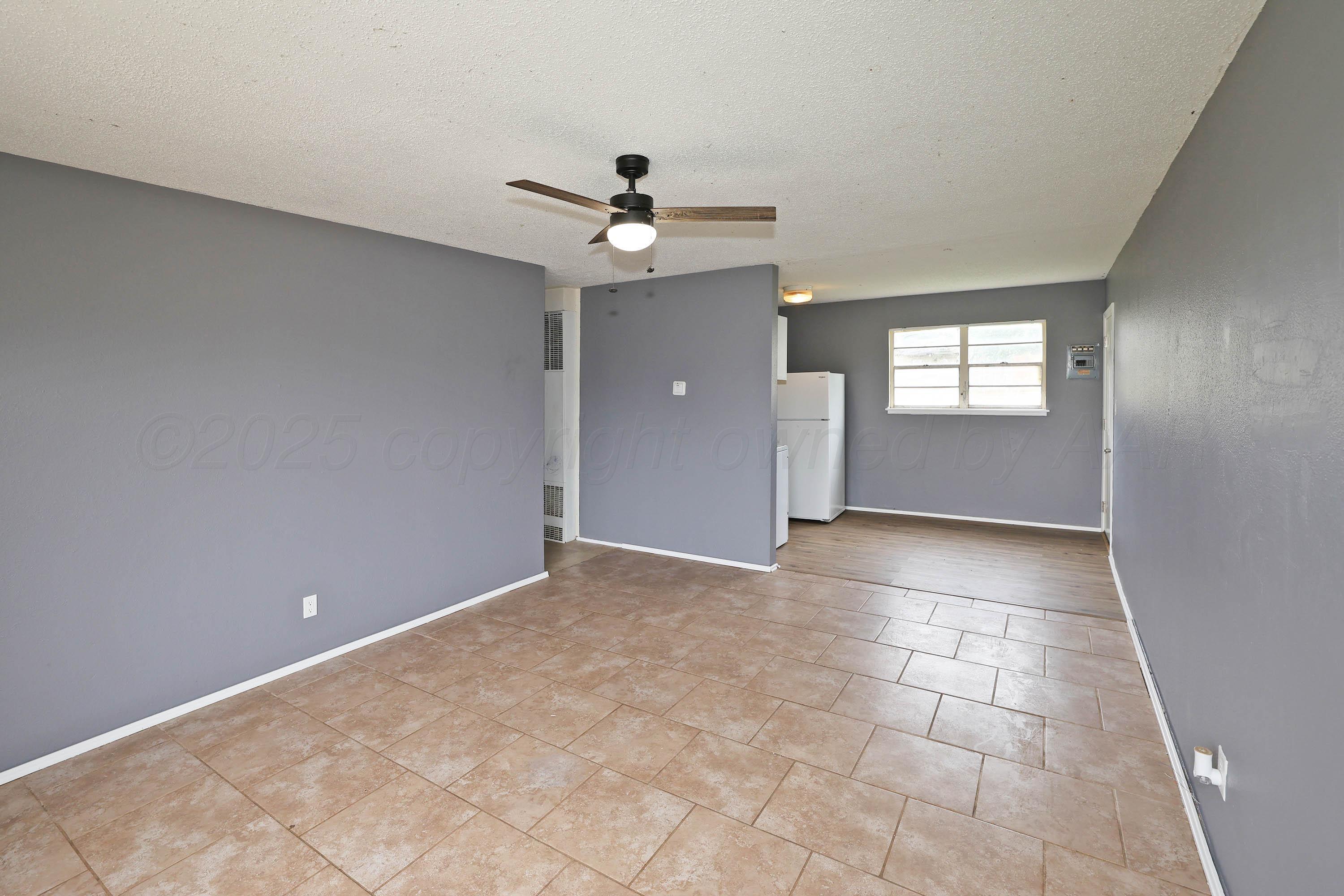 3810 Mesa Verde Drive Amarillo, TX 79107 - Photo 3 of 21 an empty room with a chandelier fan and windows