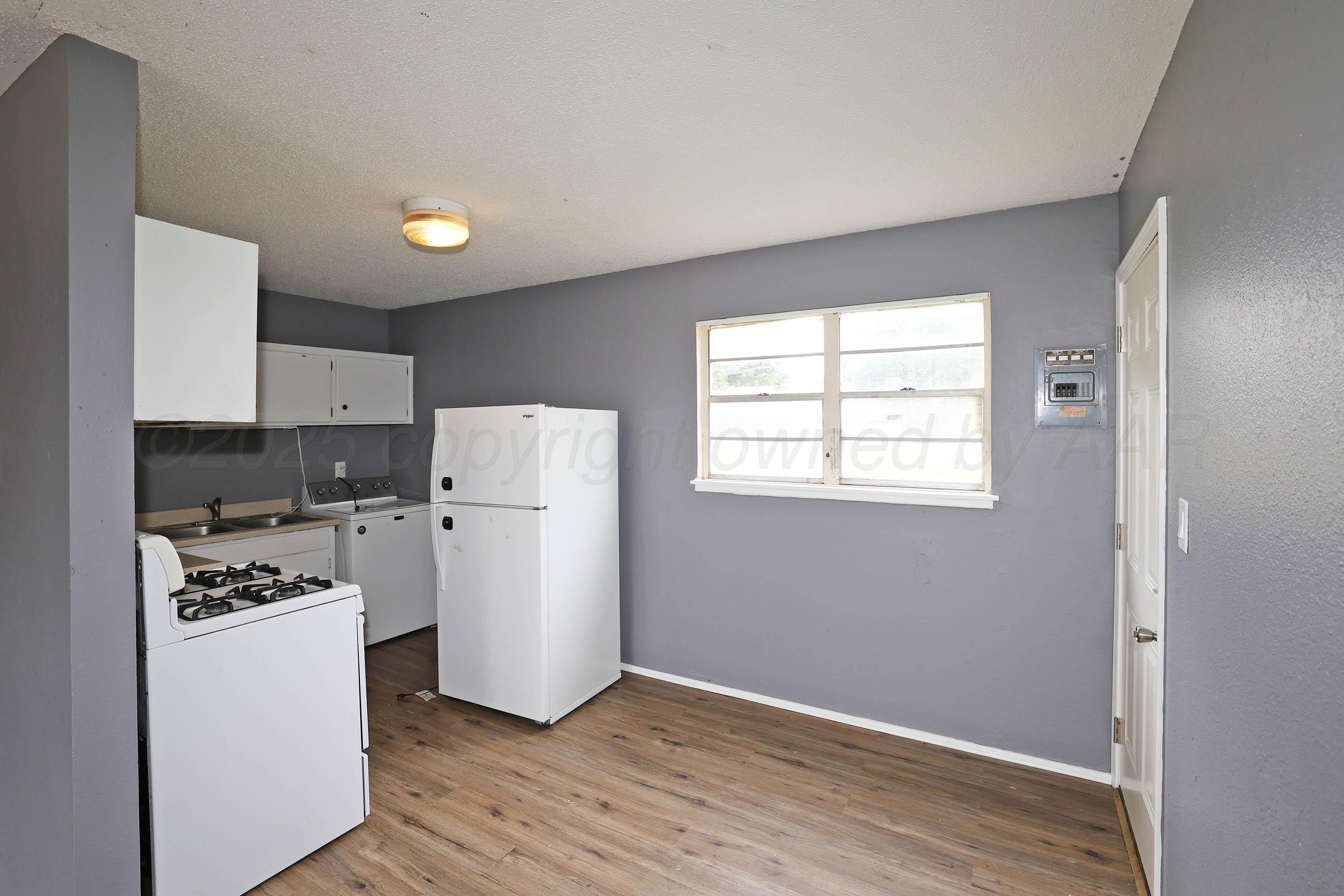 3810 Mesa Verde Drive Amarillo, TX 79107 - Photo 7 of 21 a kitchen with a refrigerator a stove top oven and white cabinets