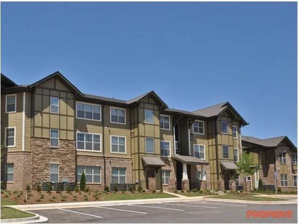 a front view of a residential apartment building with a yard