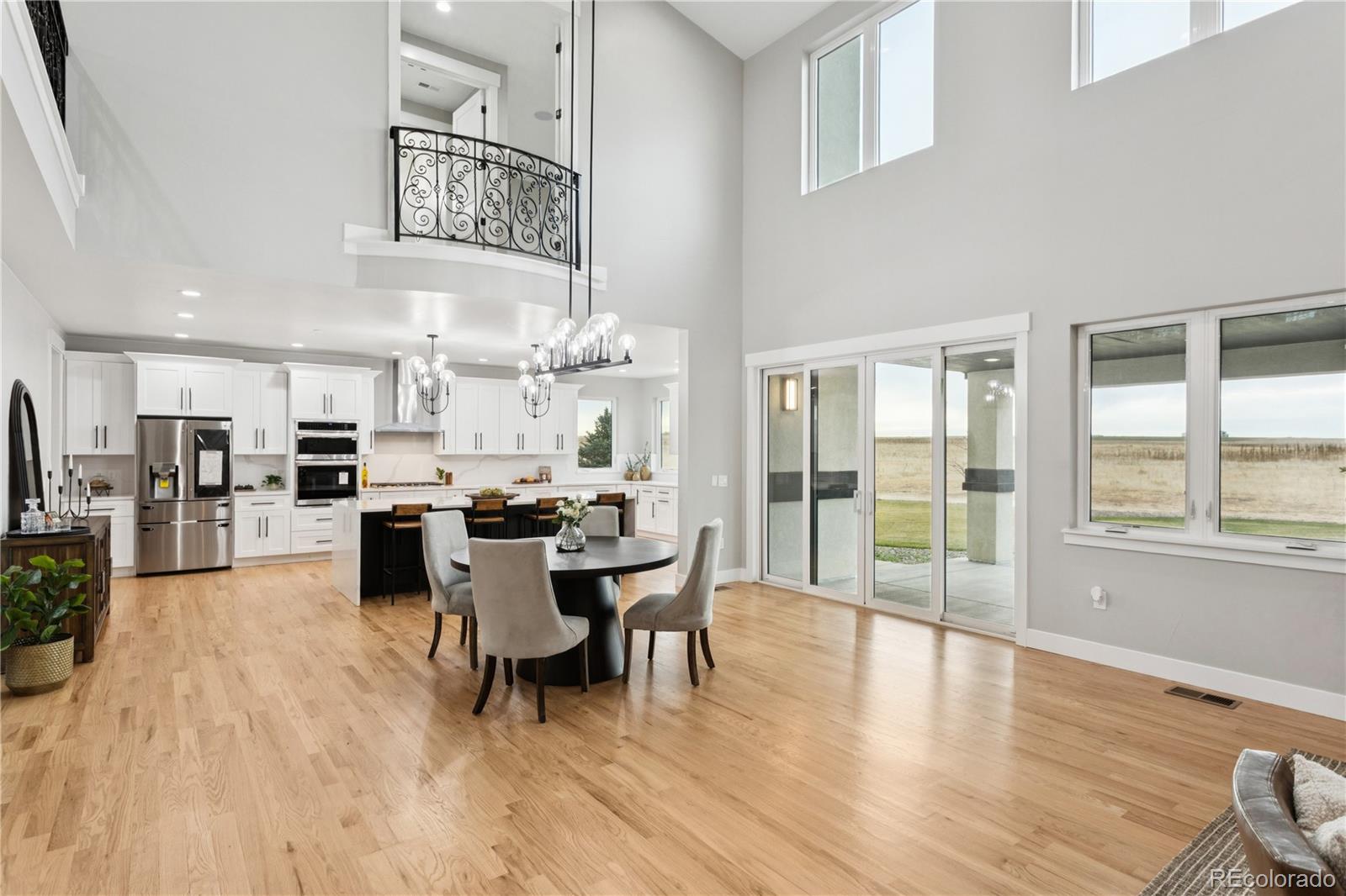 12550 Imboden Road Hudson, CO 80642 - Photo 11 of 50 a view of a dining room and livingroom with furniture wooden floor a chandelier