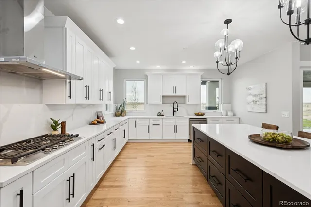 a large kitchen with stainless steel appliances granite countertop a lot of counter space and wooden floor