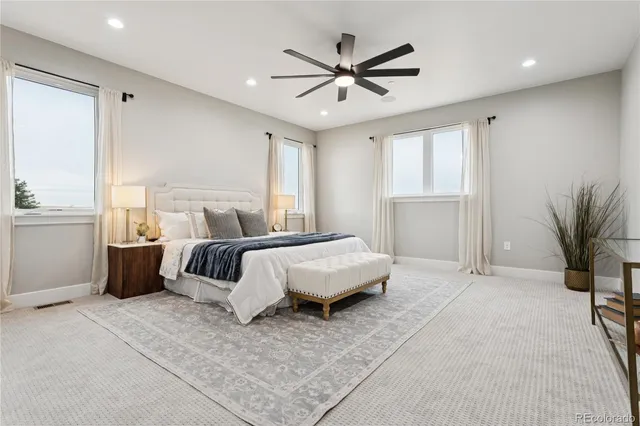 a spacious bedroom with a bed and a ceiling fan