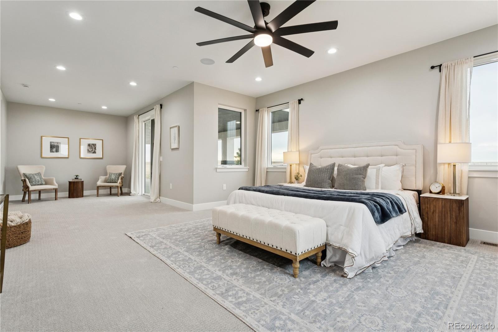 12550 Imboden Road Hudson, CO 80642 - Photo 21 of 50 a spacious bedroom with a large bed and a chandelier