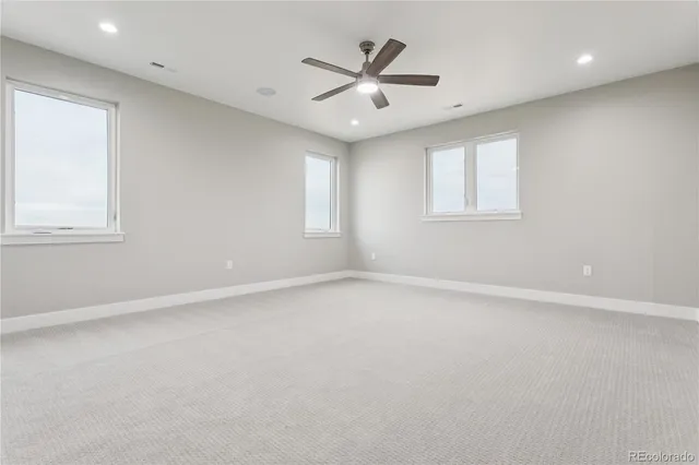 an empty room with a window and a ceiling fan
