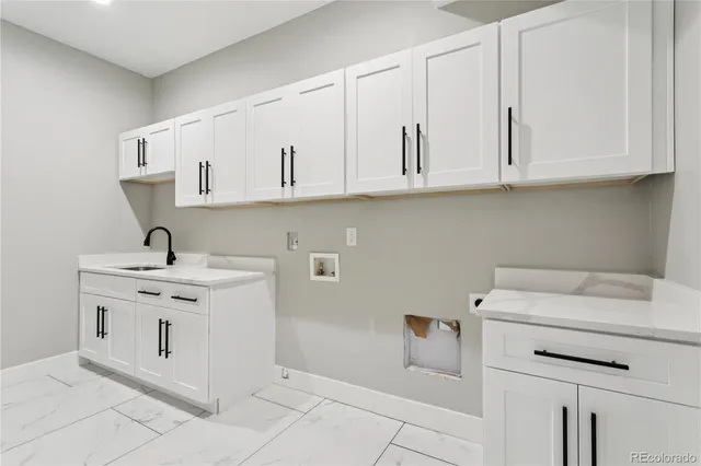 a kitchen with white cabinets and sink