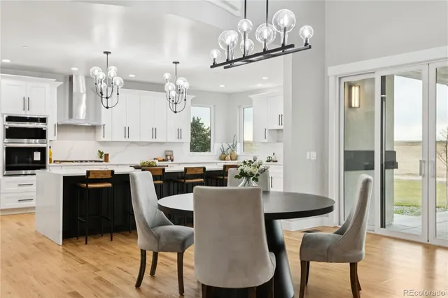 a view of a dining room with furniture a chandelier and wooden floor