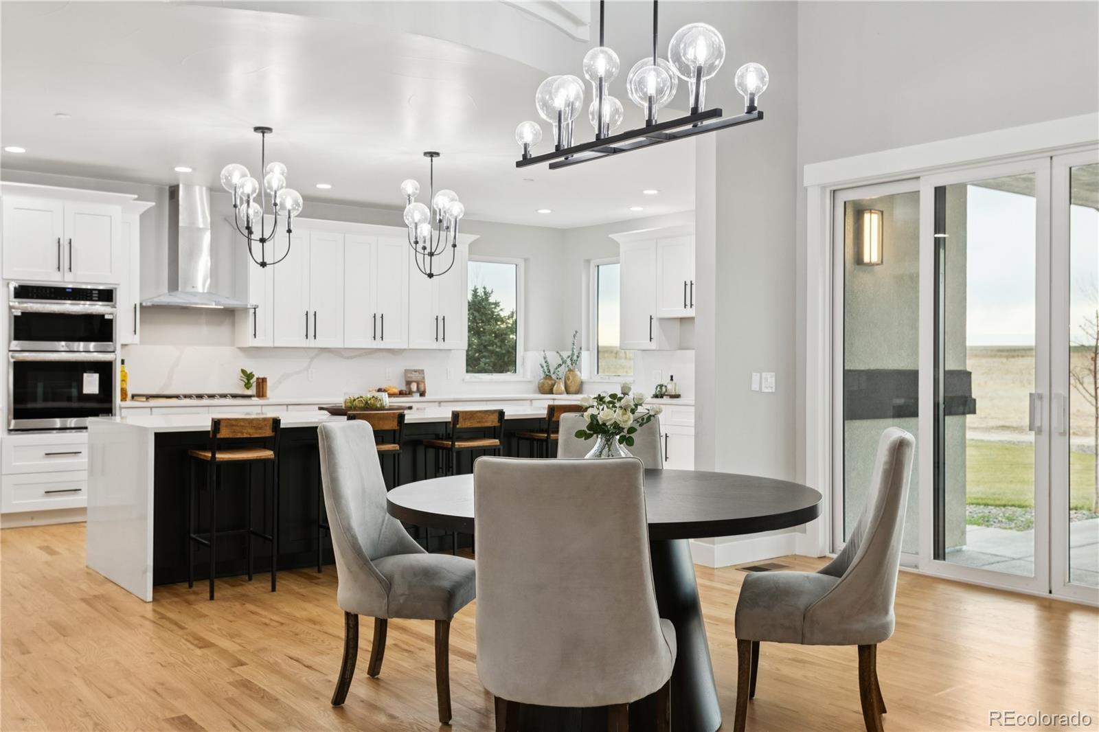 12550 Imboden Road Hudson, CO 80642 - Photo 48 of 50 a view of a dining room with furniture a chandelier and wooden floor