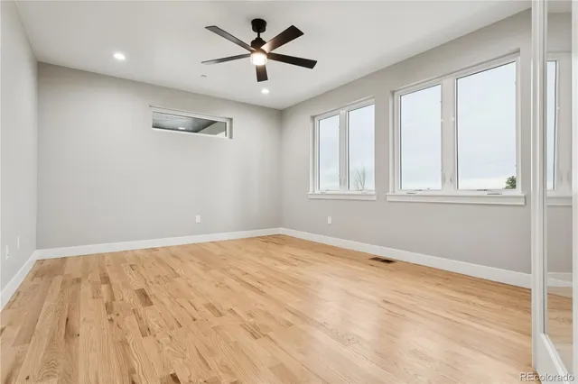 an empty room with a window and a ceiling fan