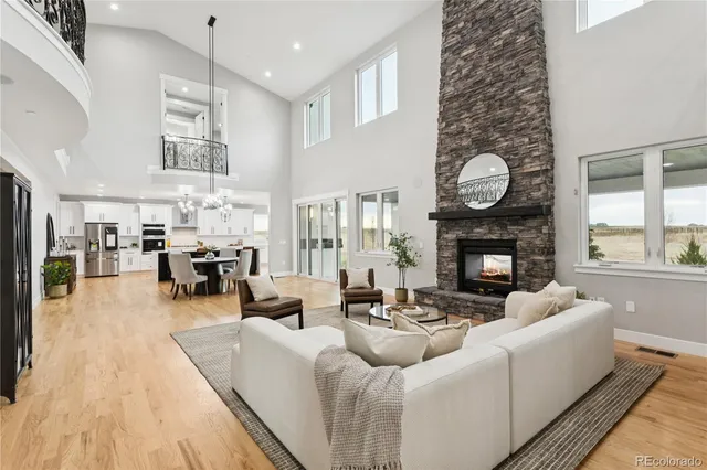 a living room with furniture a fireplace and a large window