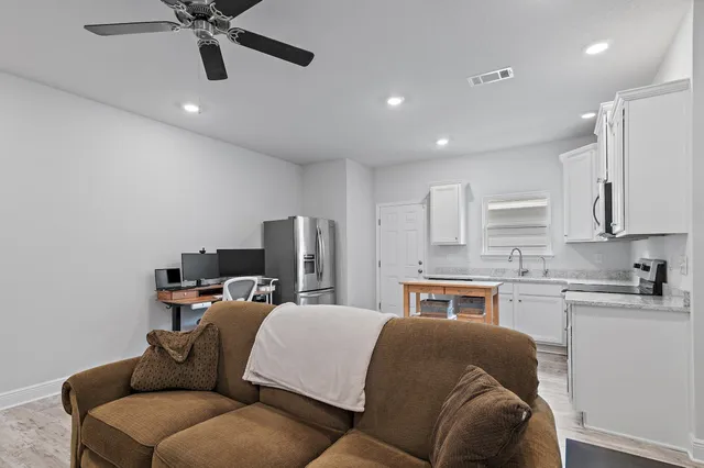a view of kitchen with stainless steel appliances granite countertop a stove a sink a microwave and dining table