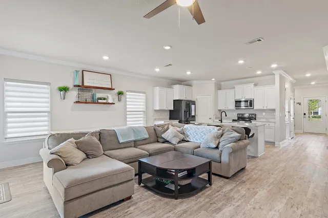 a living room with furniture white walls and kitchen view