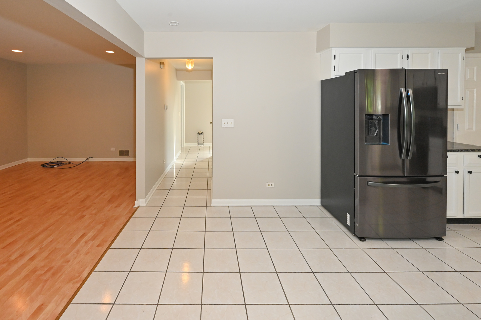 500 Greenview Lane Wheeling, IL 60090 - Photo 14 of 51 a view of a refrigerator in kitchen and an empty room in wooden floor