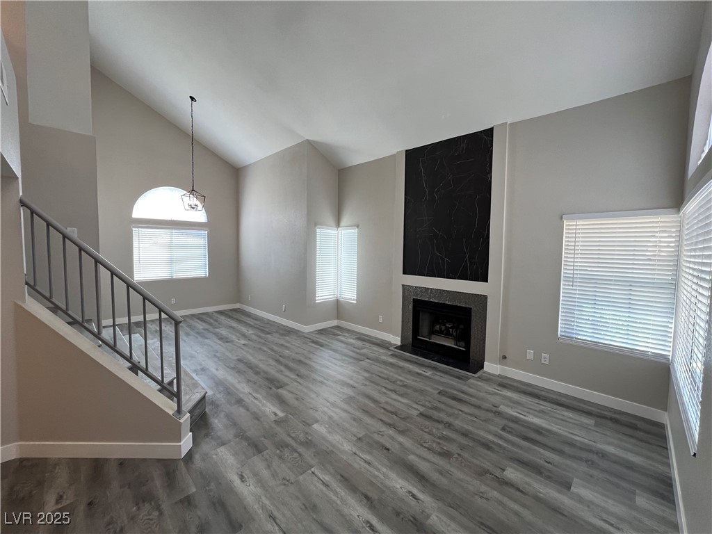 3238 Canyon Terrace Drive Laughlin, NV 89029 - Photo 3 of 41 Unfurnished living room with high vaulted ceiling, a fireplace, stairs, and dark wood-style floors