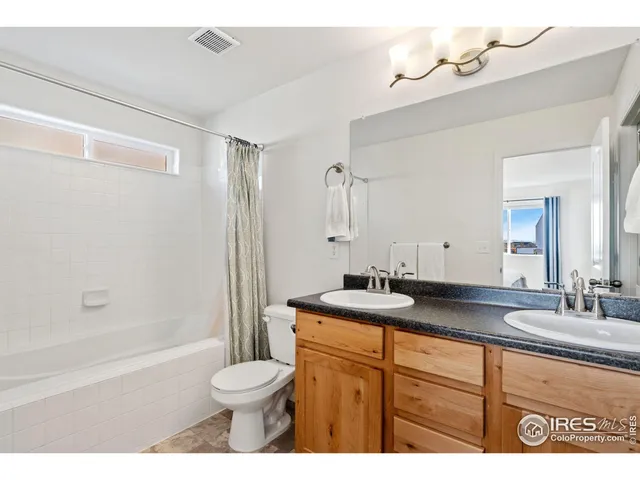 a bathroom with a granite countertop sink toilet a large mirror a shower and bathtub
