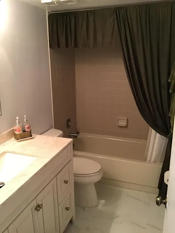 a bathroom with a granite countertop sink toilet and bathtub