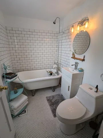 a bathroom with a toilet sink and mirror