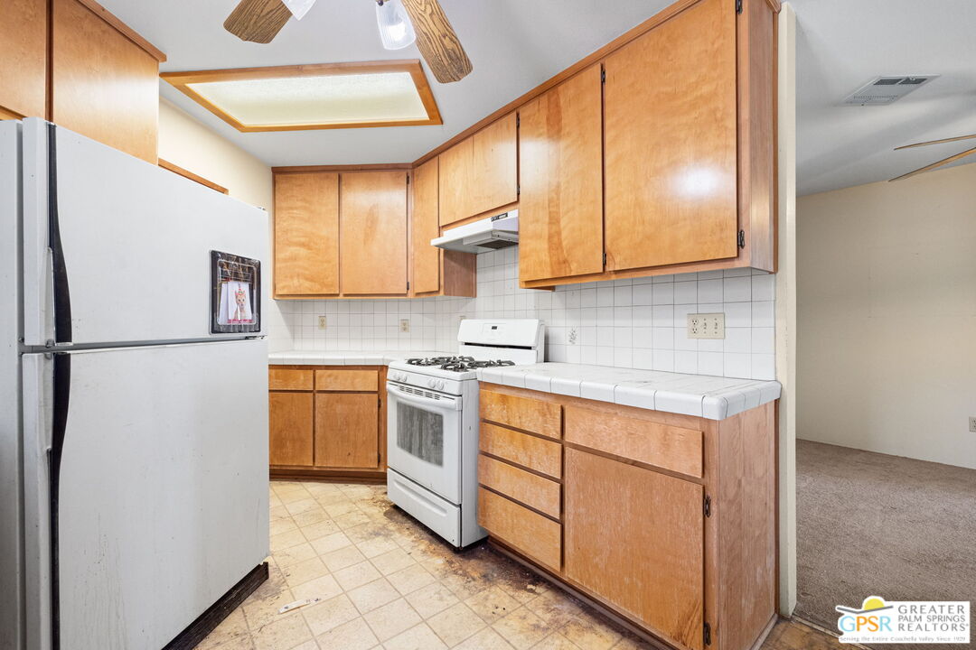 68600 Risueno Road Cathedral City, CA 92234 - Photo 14 of 30 a kitchen with stainless steel appliances granite countertop a sink a stove and a refrigerator
