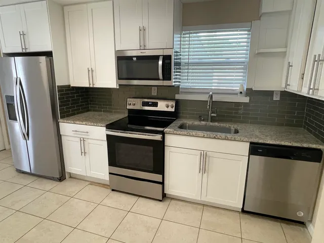 a kitchen with cabinets stainless steel appliances and a sink