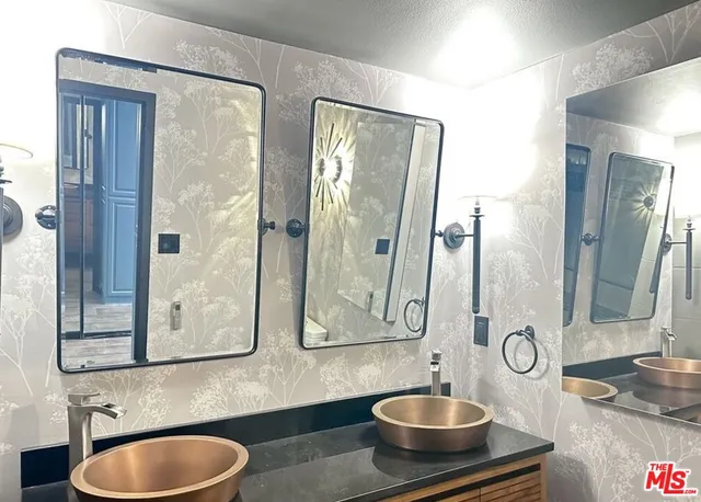 a bathroom with double vanity sink and a mirror