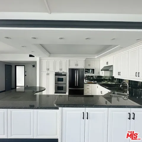 a kitchen with stainless steel appliances kitchen island granite countertop a sink and cabinets